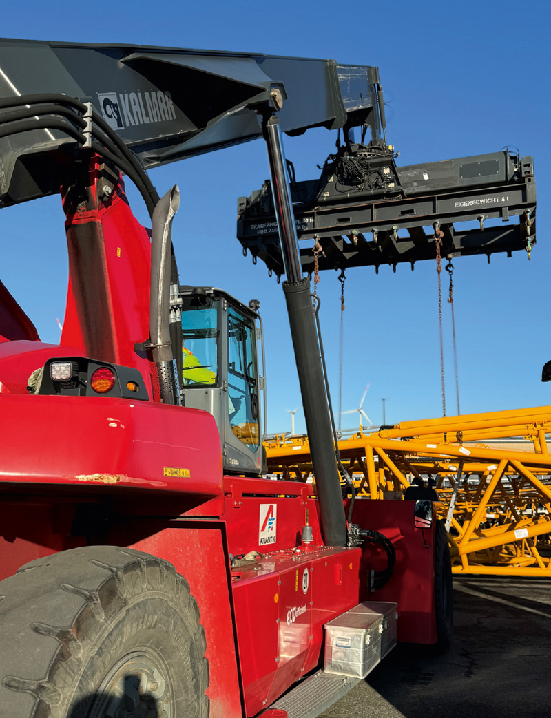 Reach stacker that lifts a crane part