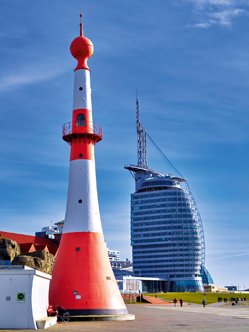 Blick auf einen Leuchtturm mit Atlantic Hotel Sail City im Hintergrund