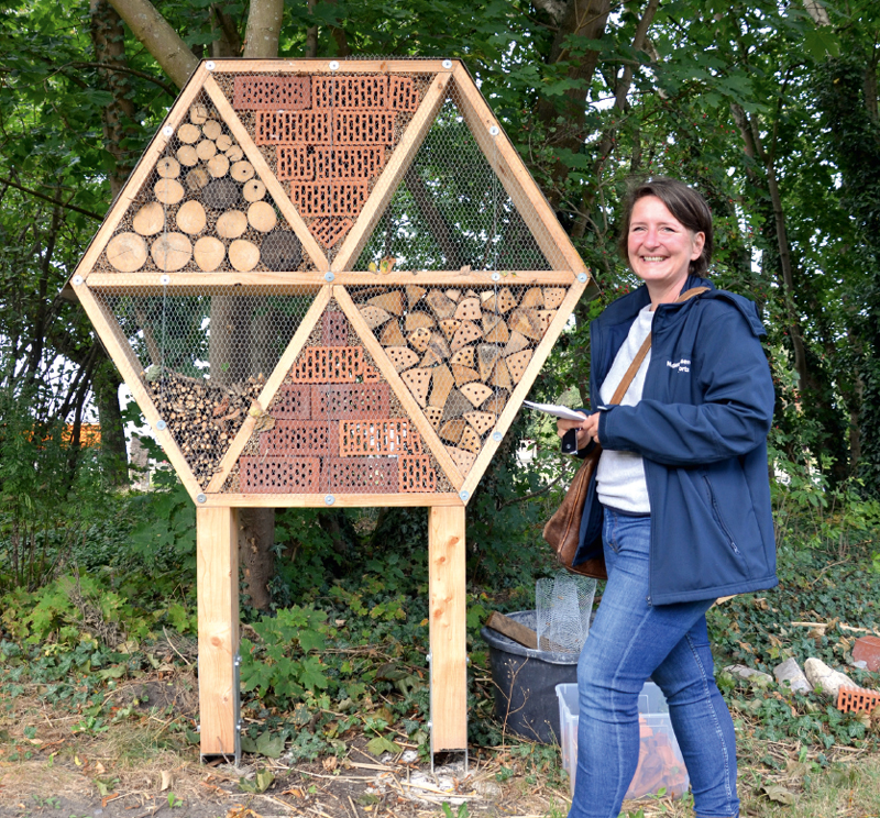 Franziska Walther, stellvertretende Leiterin der NPorts-Niederlassung in Brake, zeigt das von ihren Kollegen selbstgebaute Insektenhotel im Garten des Hafenhauses.