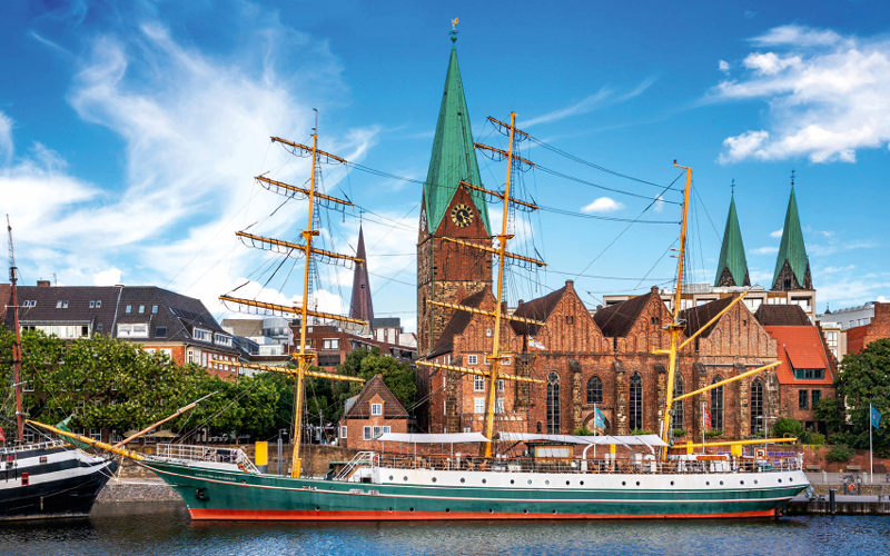 View of the historic sailing ship Alexander von Humboldt with St Martini's Church and Bremen Cathedral in the background